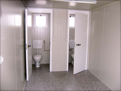 Cabine sanitaire avec toilettes séparées et douche indépendante